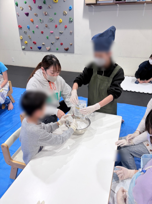 コーチと一緒に団子をこねるお子様